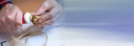 Plumber preparing fitting sealing with hemp fibers; panoramic bannerの写真素材