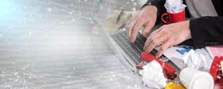 Businessman working on a cluttered and messy desk; panoramic banner