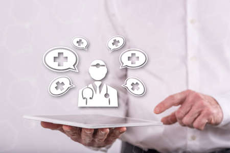 Medical assistance concept above a tablet held by a man in backgroundの写真素材