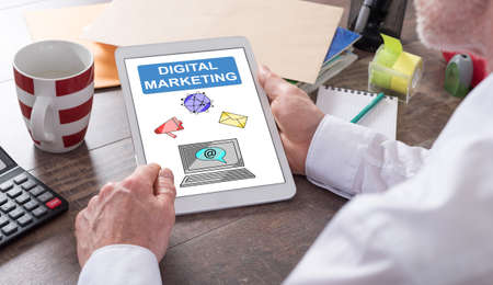 Digital marketing concept shown on a tablet held by a manの写真素材