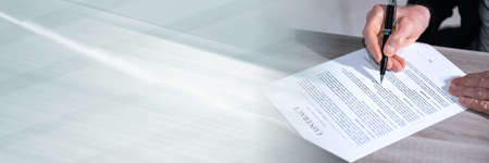 Male hands checking content of a contract; panoramic banner