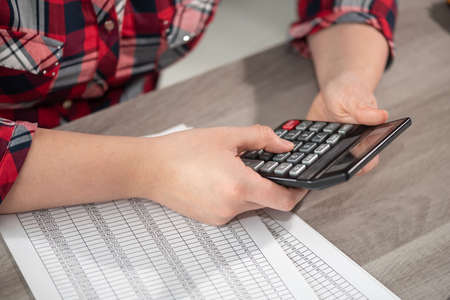 Woman using calculator and working on financial data