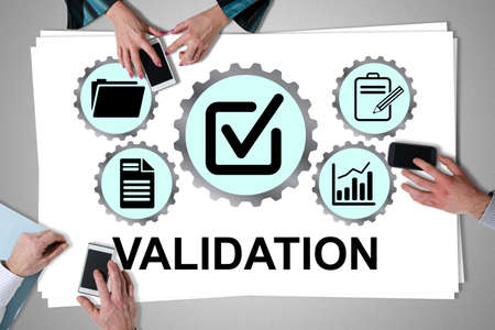 Validation concept placed on a desk with hands using smartphones