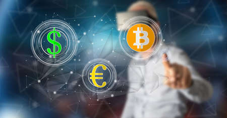 Man with vr headset touching a currency exchange concept on a touch screen with his finger
