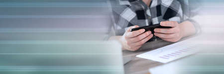 Female hands using a mobile phone; panoramic banner