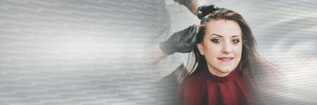 Hairdresser coloring female client hair; panoramic bannerの写真素材