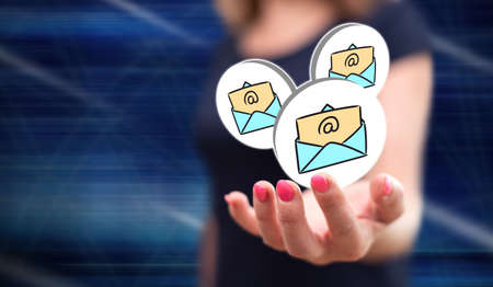 E-mail concept above the hand of a woman in backgroundの写真素材