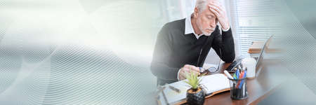 Portrait of overworked senior businessman sitting in office; panoramic bannerの写真素材