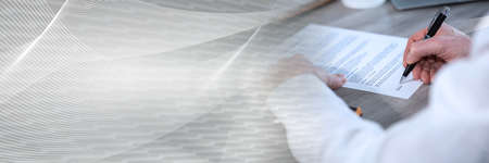 Hand of businessman signing a contract; panoramic banner
