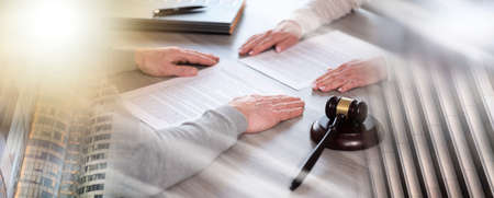 Hands of couple sitting face to face. concept of divorce with judge gavel; multiple exposure
