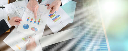 Businesspeople having a discussion about financial report at office; multiple exposureの写真素材