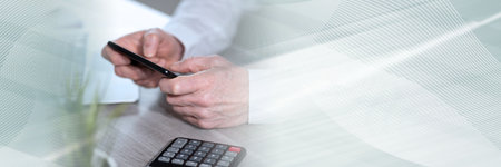 Man holding and using his mobile phone; panoramic bannerの写真素材