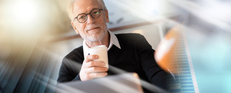Senior businessman having a coffee break at office; multiple exposureの写真素材