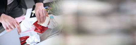 Disorganized businessman looking for documents on his messy desk; panoramic bannerの写真素材