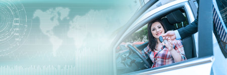 Car salesman giving car keys to pretty young woman; panoramic bannerの写真素材