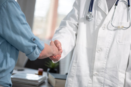 Female doctor shaking hands with her patientの写真素材