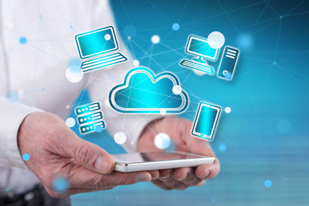 Cloud computing concept above a smartphone held by handsの写真素材