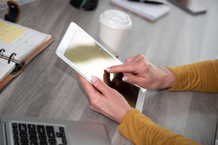 Female hands using digital tablet at workplaceの写真素材