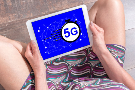 Woman sitting on the floor with a tablet showing 5g conceptの写真素材