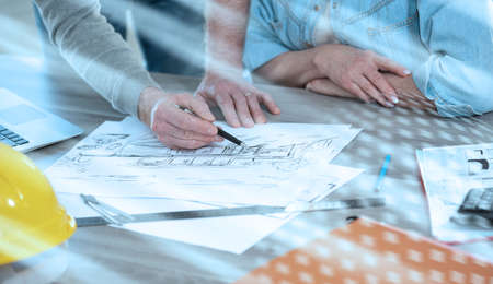Architects working on sketch of new construction project; light effect
