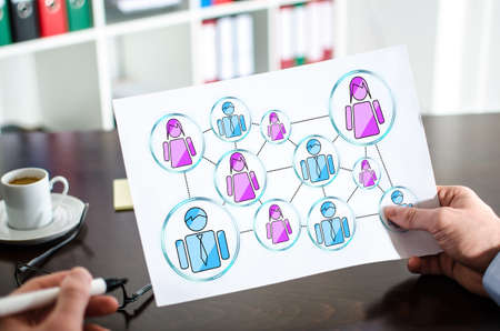 Hand holding a paper showing social network concept