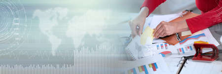 Disorganized businesswoman looking for documents on her messy desk; panoramic bannerの写真素材