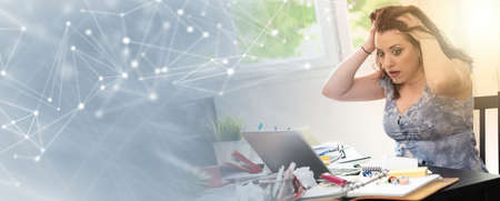 Overworked young businesswoman sitting at a messy desk; panoramic bannerの写真素材