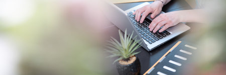 Female hands working on laptop in office; panoramic bannerの写真素材
