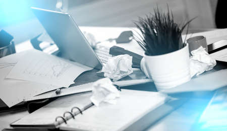 Messy and cluttered office desk; light effectの写真素材
