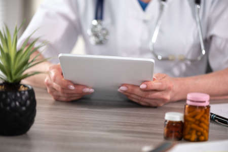Female doctor using digital tablet at workplace