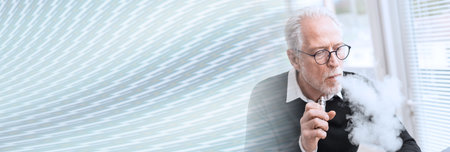 Portrait of senior man smoking electronic cigarette; panoramic bannerの写真素材