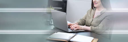 Young attractive businesswoman working on laptop at home; panoramic banner