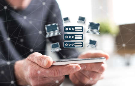 Hands of man holding a smartphone with hosting conceptの写真素材