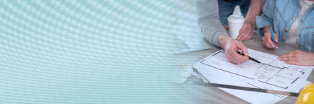 Architects working on blueprint of new construction project; panoramic banner