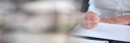 Angry businesswoman hitting her desk with her clenched fist; panoramic bannerの写真素材
