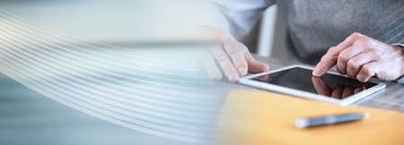 Businessman working on digital tablet, closeup; panoramic banner