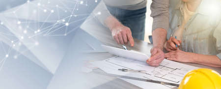 Architects working on new construction project and using digital tablet; panoramic banner