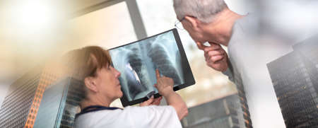 Female doctor showing xray to her patient in medical office; multiple exposure