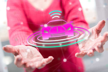 Autonomous car concept above the hands of a woman in background