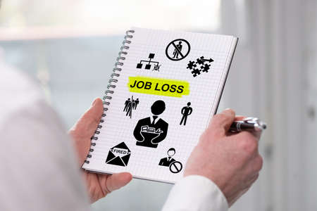 Hand holding a notepad with job loss conceptの写真素材