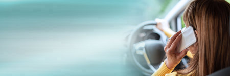 Woman talking on mobile phone while driving; panoramic banner