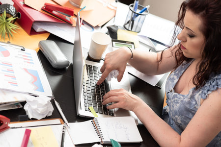 Businesswoman working on a cluttered and messy desk