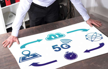 Man watching a 5g concept placed on a deskの写真素材