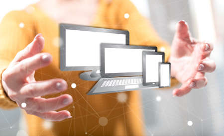 Technology devices concept between hands of a woman in background
