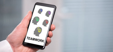 Hand holding a smartphone with teamwork concept