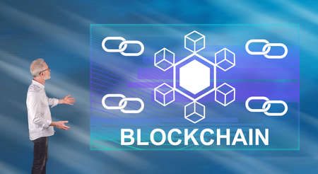 Businessman showing a blockchain concept on a wall screen