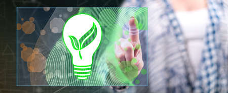 Woman touching a green energy concept on a touch screen with her fingerの写真素材