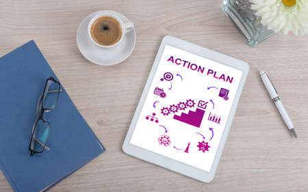 Top view of a desk with action plan concept on a digital tabletの写真素材