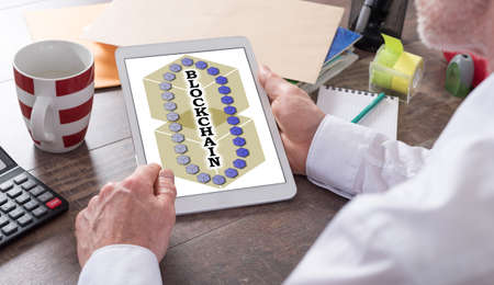 Blockchain technology concept shown on a tablet held by a man