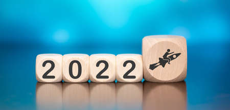 Wooden cube with concept of business success in new year 2022 on blue backgroundの写真素材